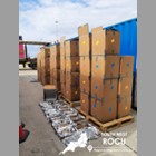 Brown cardboard boxes piled high with the contents of one box emptied in front.