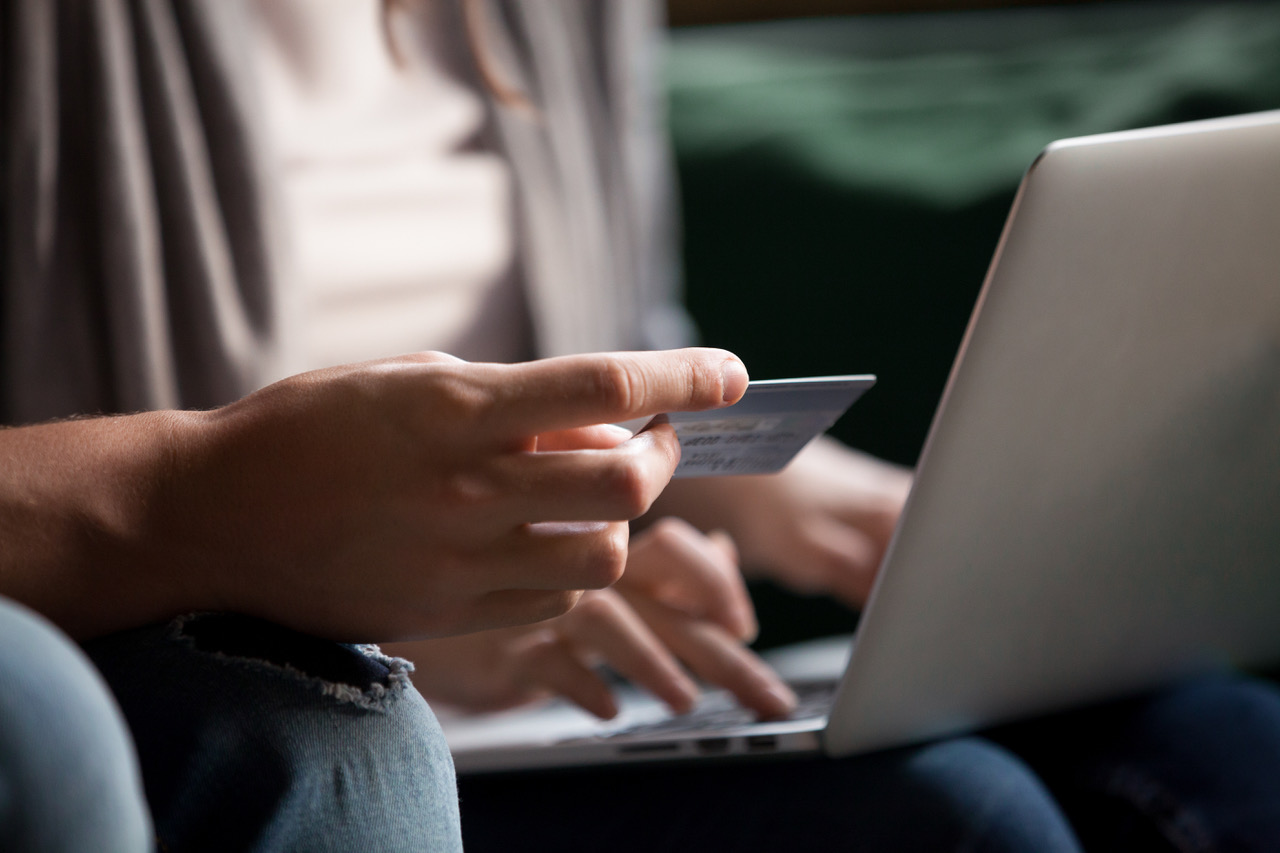 Someone with their bank card and a laptop